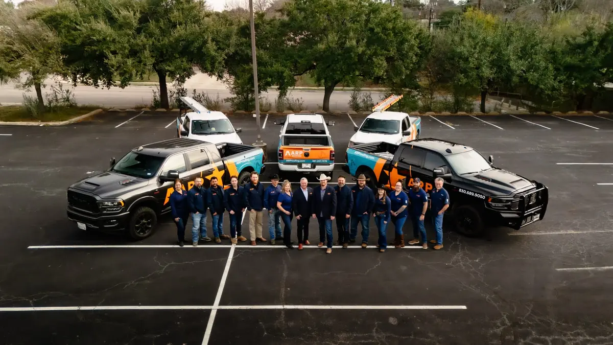 The ARP Roofing & Remodeling team standing in front of the company trucks