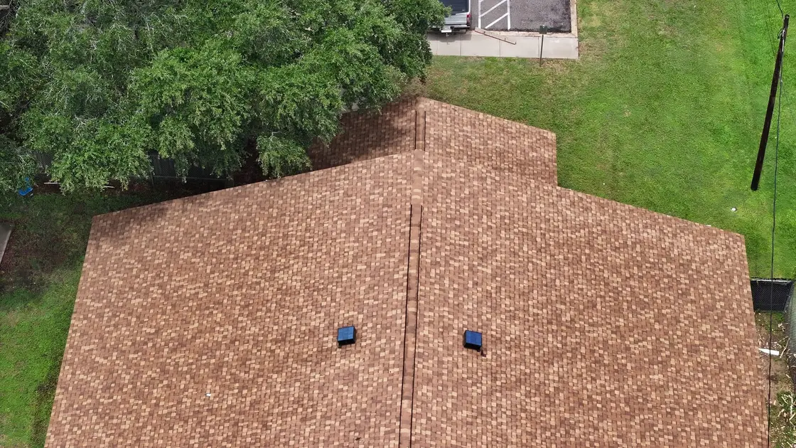 Aerial view of an asphalt shingle roof with several exhaust vents set near the ridge