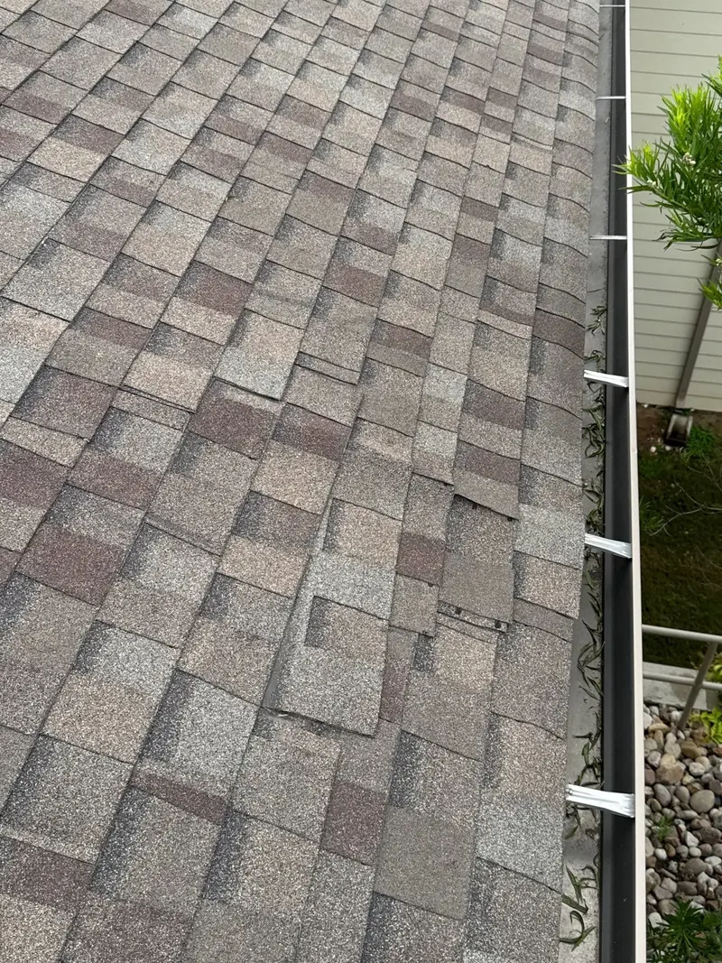 Lifted shingle tabs let wind-driven rain under the course — one of the most common leak paths we trace on a San Antonio repair.