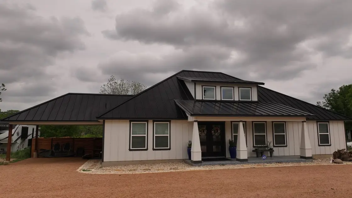 Black metal standing seam roof on a residential home, showing the lower-cost modern profile