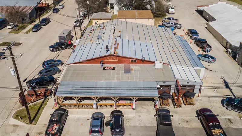 ARP's metal retrofit on Old 300 BBQ in Blanco — panels formed to the run, seams locked, every penetration flashed by hand. Drive by and judge the details yourself.