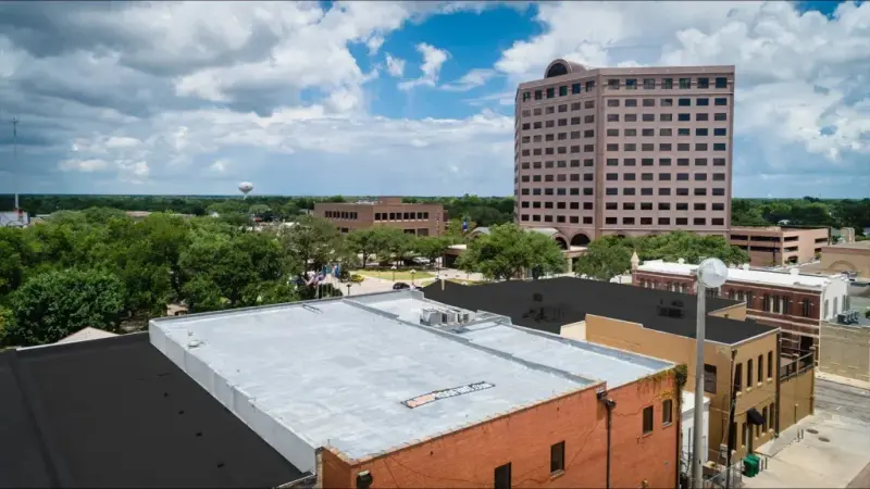 A white TPO membrane roof with rooftop HVAC units on a San Antonio commercial building