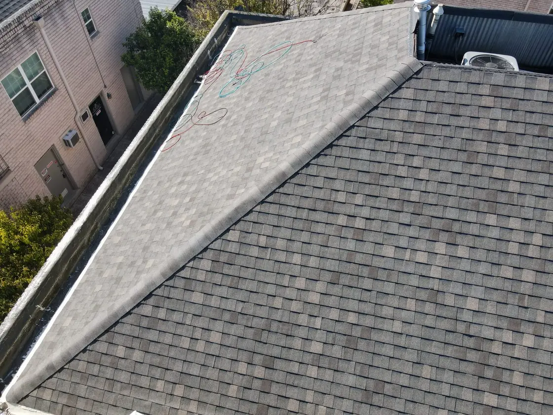 An inspector walking a commercial TPO flat roof documenting membrane and drainage conditions