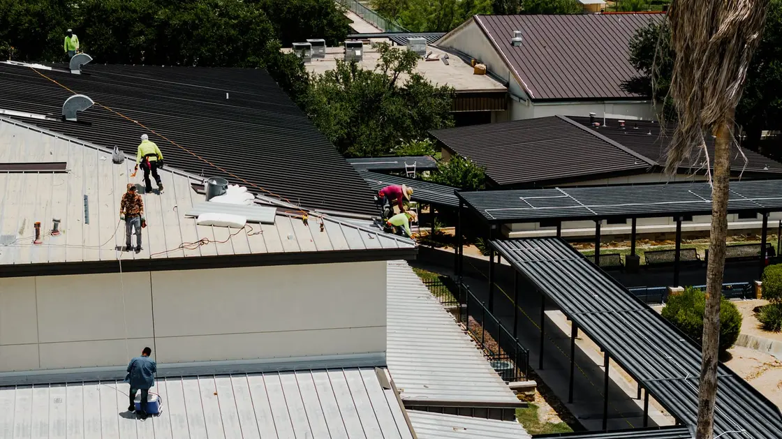 ARP crew installing a concealed-fastener standing seam metal roof on a Texas commercial building
