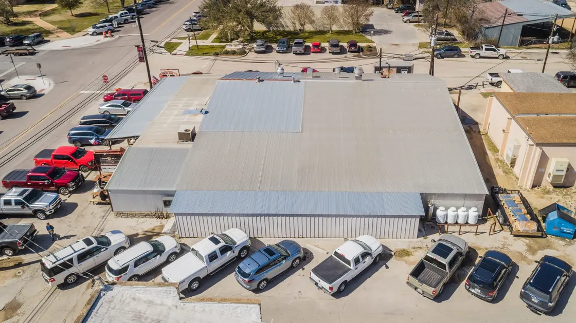 Aerial view of an aging metal roof on a Texas commercial warehouse, the kind of building a metal-over-metal recover fits