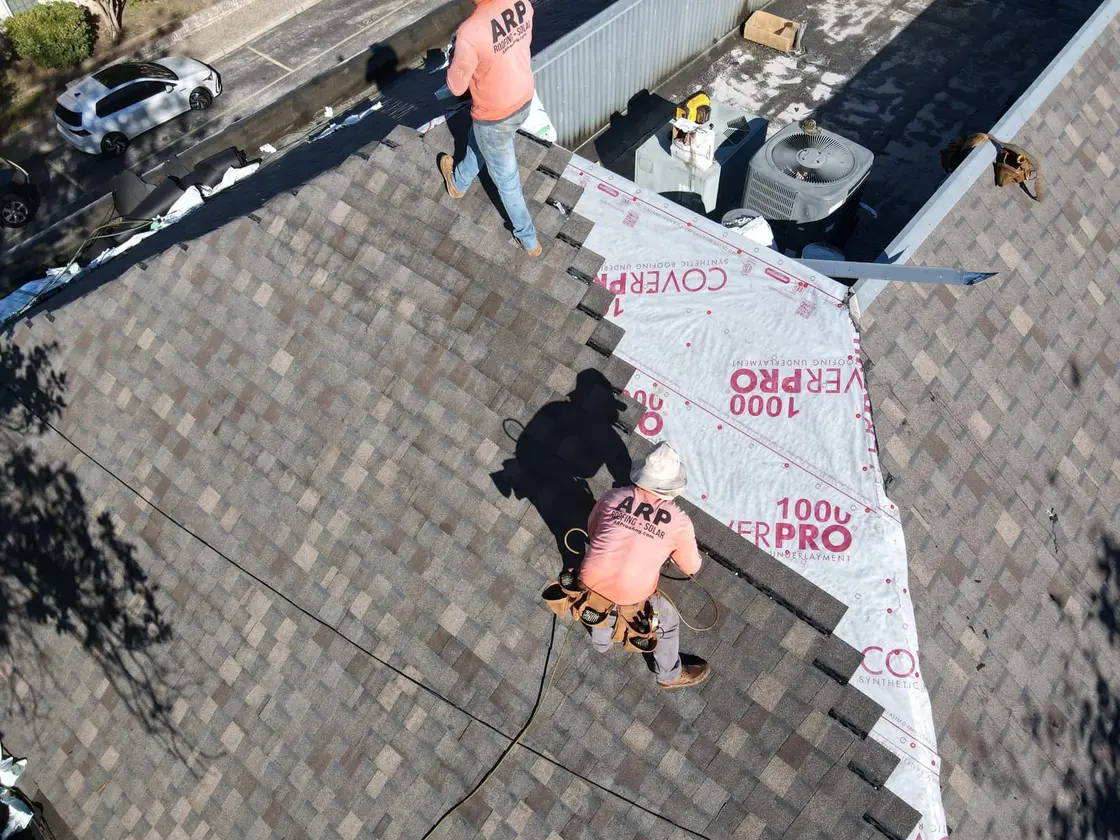 ARP-supervised crew installing TPO membrane on a commercial flat roof