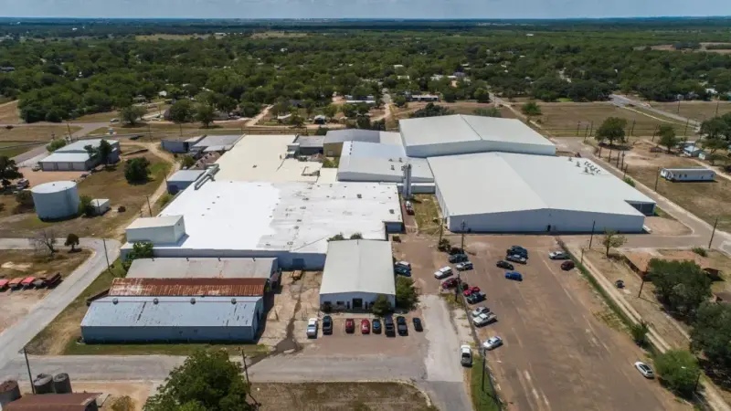 An aerial view of a San Antonio commercial warehouse complex with white TPO flat roofs