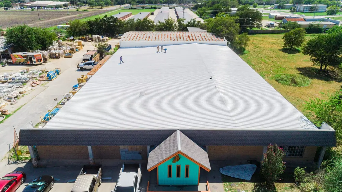 Finished white TPO membrane on a low-slope commercial warehouse roof in Texas after a full replacement