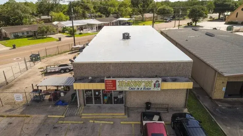 White reflective single-ply membrane on a flat commercial storefront roof