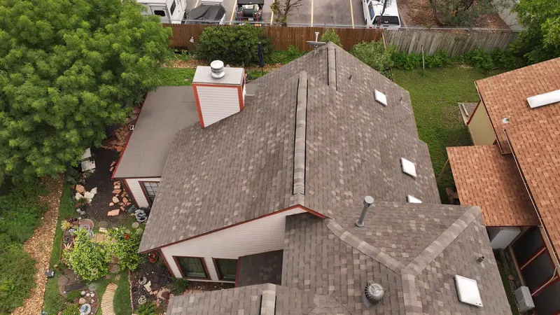 A finished architectural-shingle replacement on a Corpus Christi home — multiple peaks and skylights flashed tight, with clean lines across every transition.