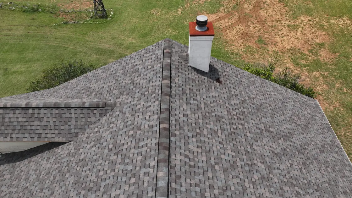 Aerial view of a gray asphalt shingle roof with a continuous ridge vent along the peak