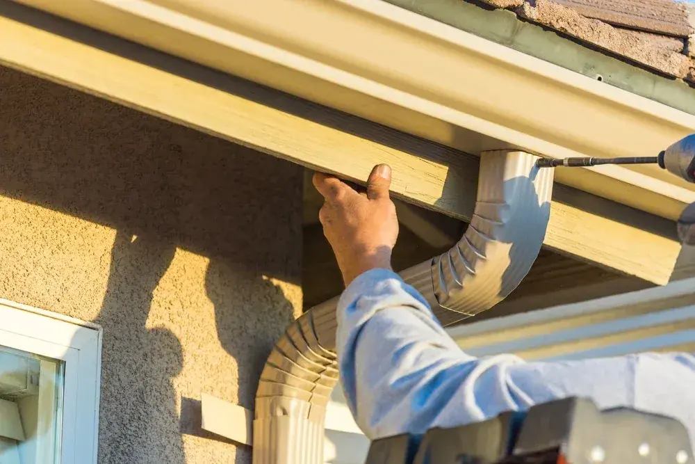 Close inspection of a residential gutter and the fascia board behind it