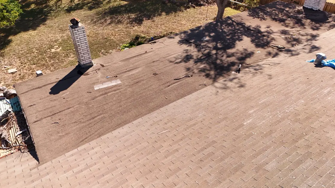 A roofer inspecting a Texas shingle roof for hail damage after a storm