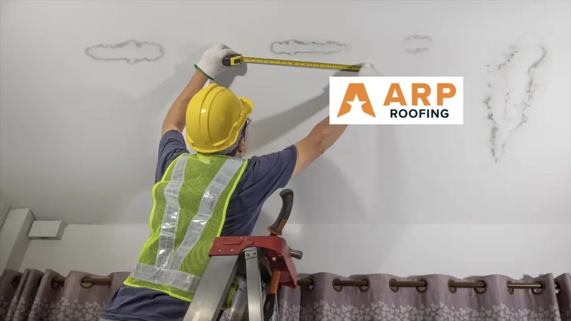 Water damage on an interior ceiling being inspected after a roof leak