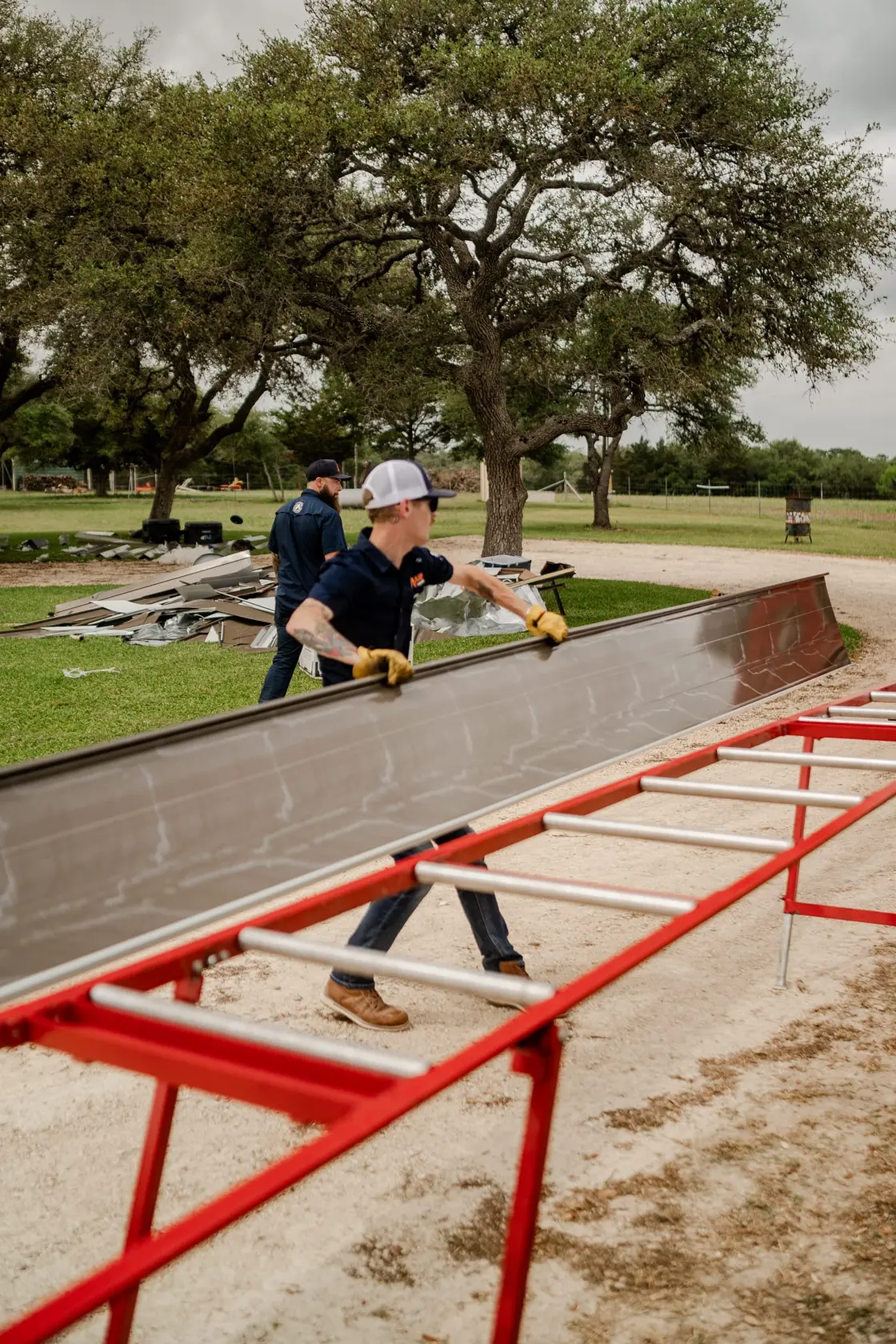 Roofing crew setting metal roofing panels during a residential install