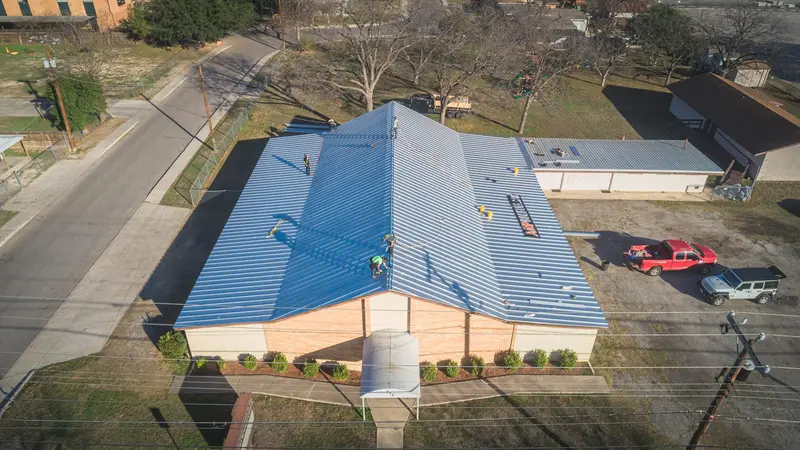ARP roll-forming a standing-seam metal panel on site — cut to the exact run of the roof, so no factory lengths get lapped in the field.