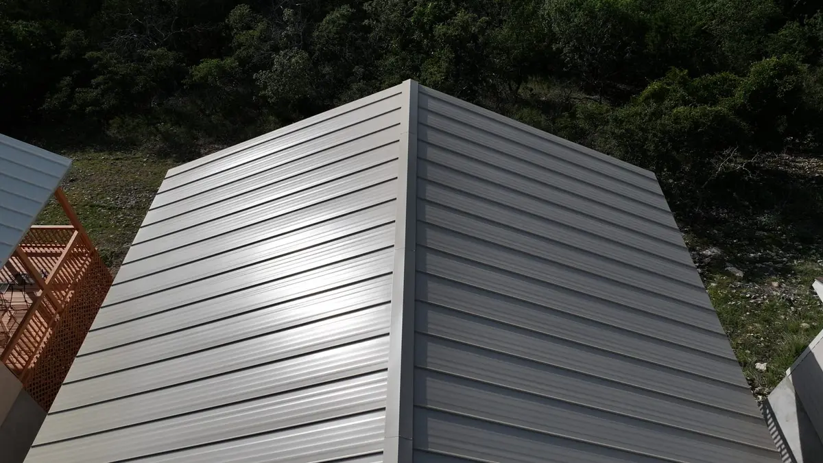 Modern metal standing seam roof on residential structure with gray horizontal panels and clean lines
