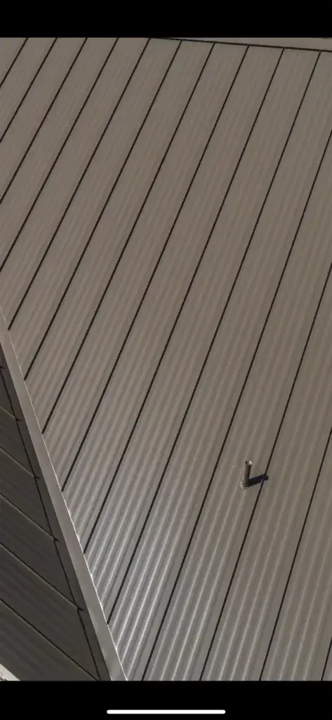 A standing seam metal roof on a Texas residential home showing clean, uniform panels