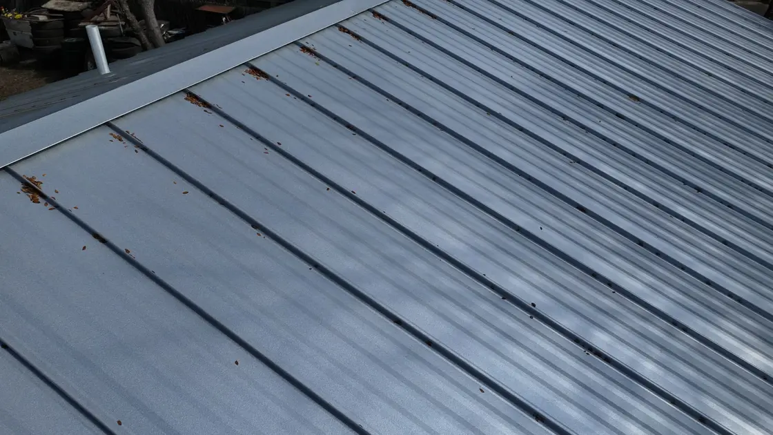 Metal standing seam roof showing rust streaks running down along the seams