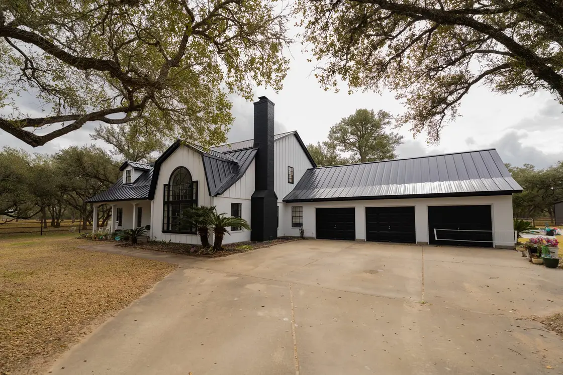 A modern farmhouse-style Texas home with a painted standing seam metal roof