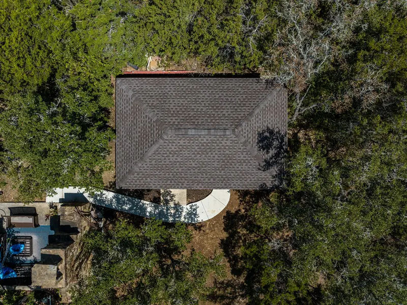 A finished architectural-shingle replacement on a Kerrville home — multiple peaks and skylights flashed tight, with clean lines across every transition.