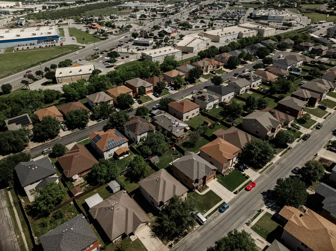 Aerial view of a Texas neighborhood showing a mix of shingle, metal, and tile roofs