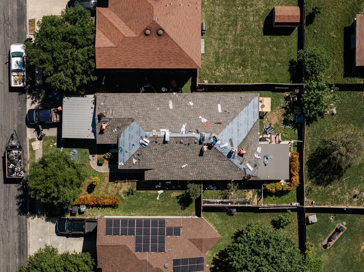 Aerial view of an ARP crew mid-replacement on a Texas home, new shingles going down over fresh underlayment
