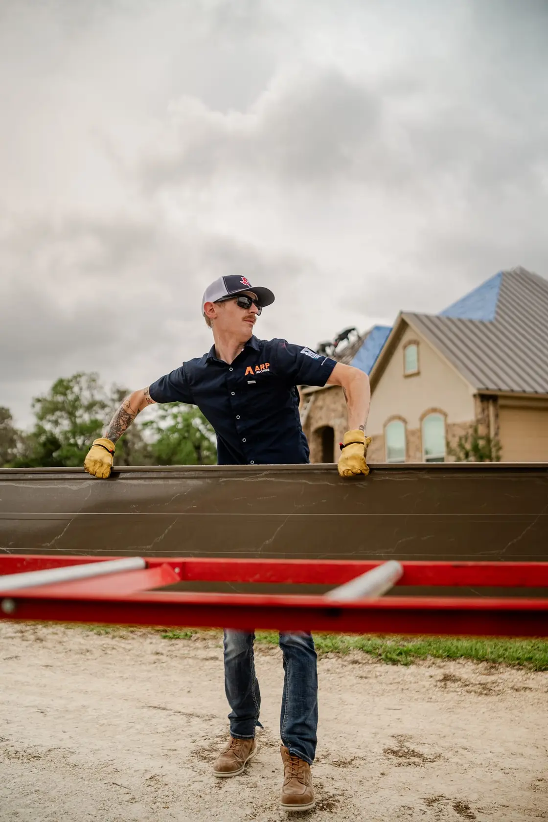 A roofer inspecting a residential asphalt shingle roof to assess damage
