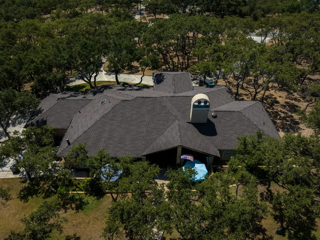 A Texas home with a newly installed architectural shingle roof in a neutral color