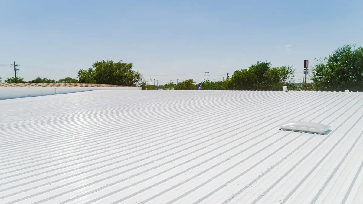 White silicone roof coating ARP applied over a corrugated metal commercial roof